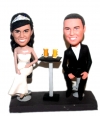 Custom bobbleheads cake toppers sitting at the table with beer
